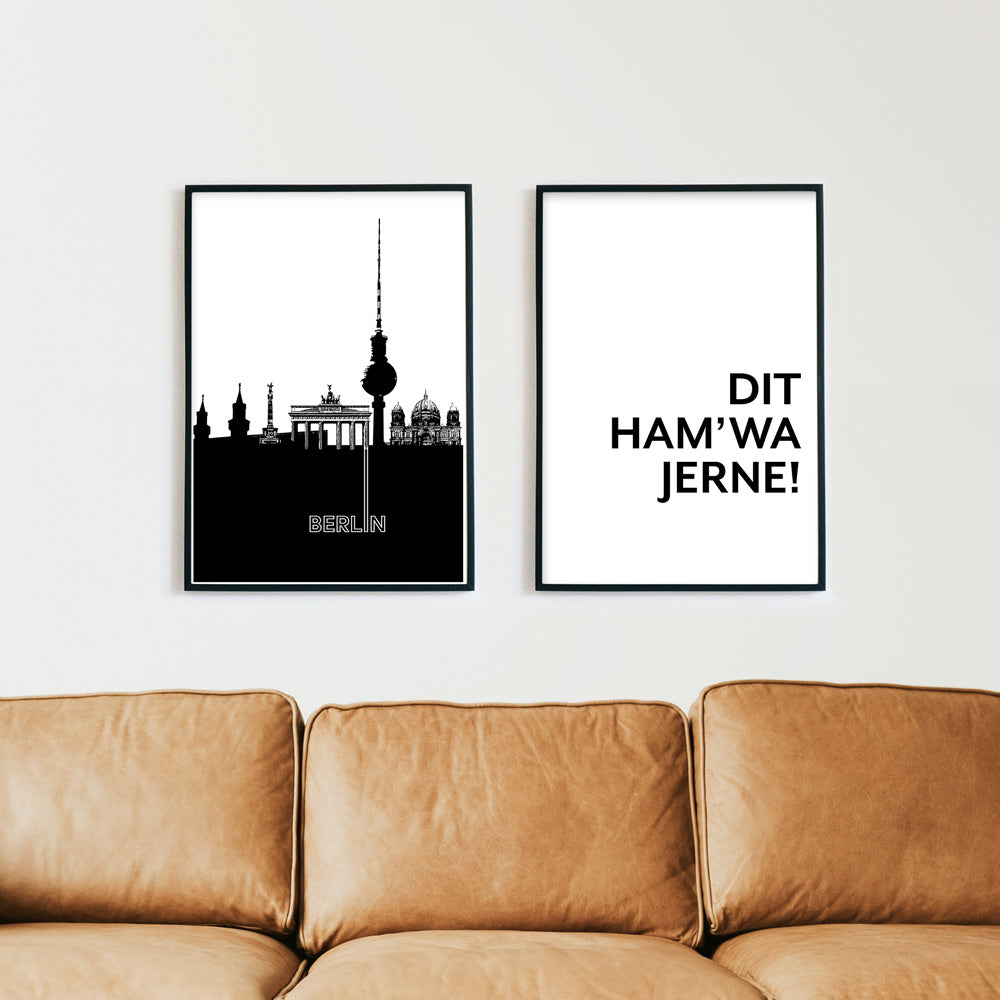 2er Berlin Poster Set in schwarz weiß. Illustration der Berliner Skyline kombiniert mit Spruch Bild. Poster in schwarzen Bilderrahmen über einem braunen Sofa