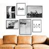 Frankfurt Poster Set in Schwarz Weiß. 4 Fotografien und 2 Spruch Bilder. Bilder in schwarzen Rahmen über einem braunen Sofa.