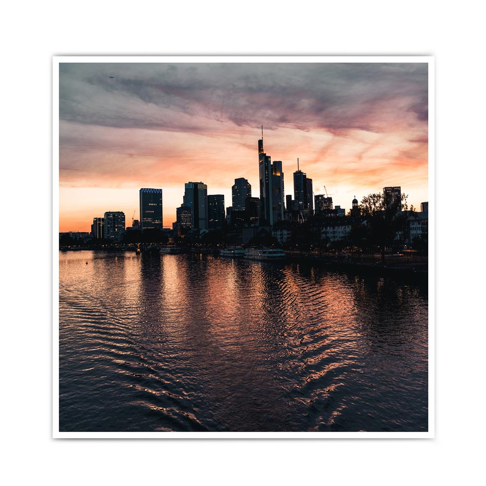 Frankfurt Skyline Poster zum Sonnenuntergang. Kraftvoller Himmel mit Spiegelungen im Main. Bild im quadratischen Format.