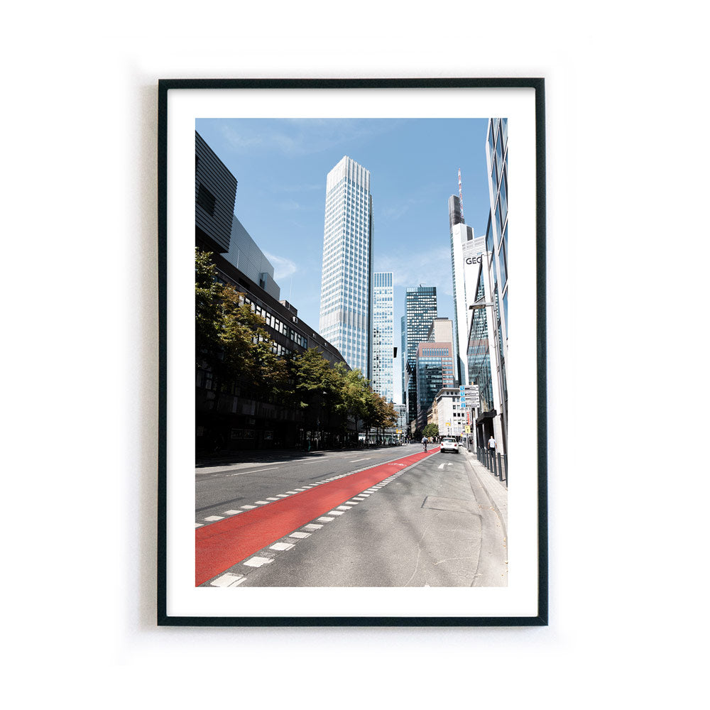 Frankfurt Poster, Straße und Fahrradweg im Vordergrund, dahinter Frankfurter Skyline. Bild mit weißen umlaufenden Rand, fertig gerahmt.