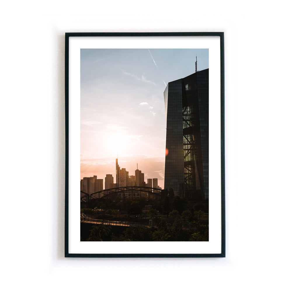 Frankfurt Poster der EZB zum Sonnenuntergang. Im Hintergrund die Frankfurt Skyline. Bild mit weißen umlaufenden Rand, fertig gerahmt.