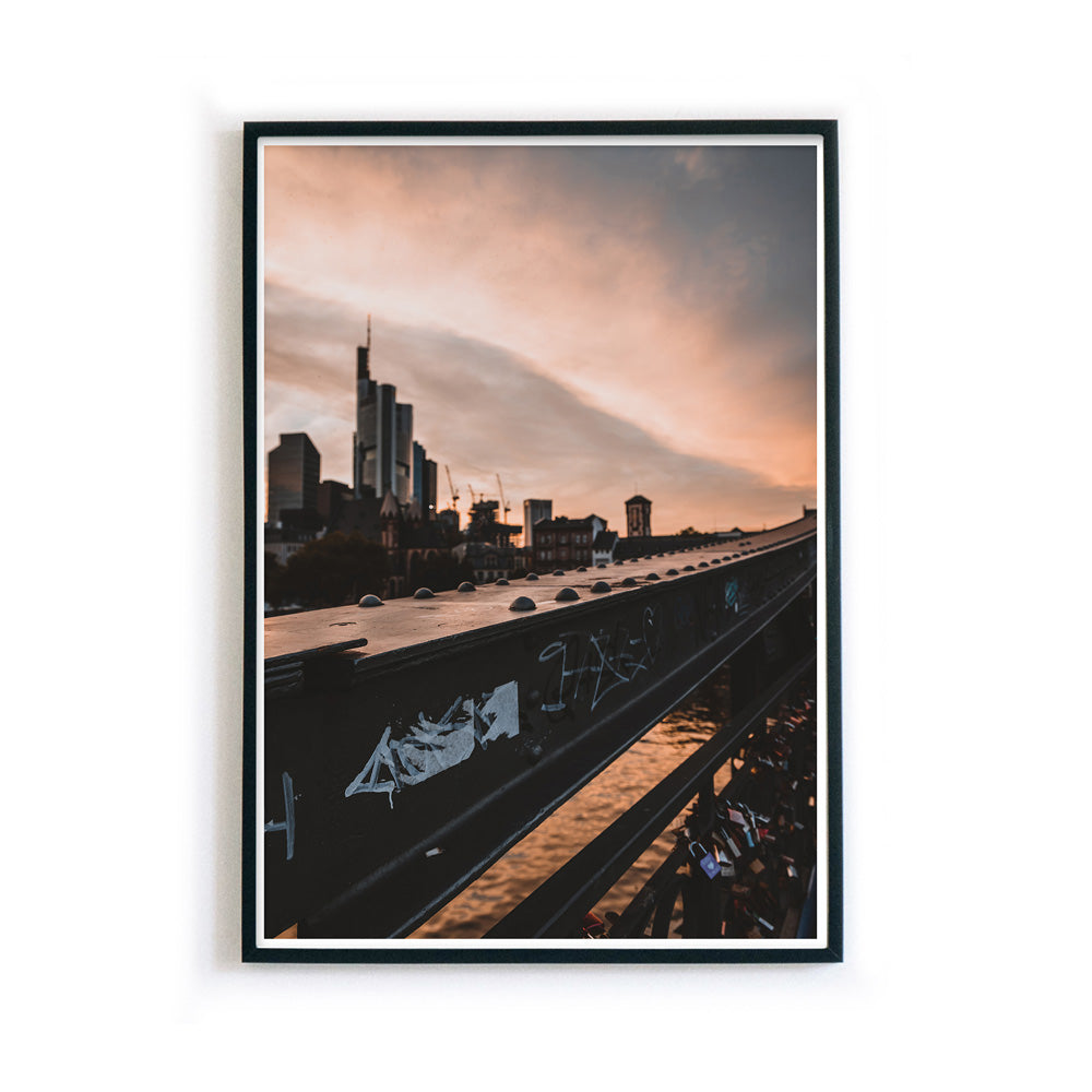 Frankfurt Poster vom Eisernen Steg zum Sonnenuntergang. Frankfurter Skyline im Hintergrund. Bild im schwarzen Rahmen.