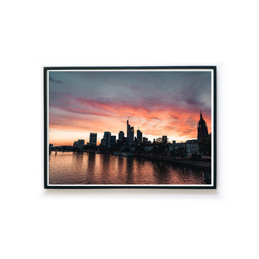 Frankfurt Skyline Poster im Querformat. Roter Himmel zum Sonnenuntergang, Spiegelung im Main. Bild im schwarzen Rahmen.
