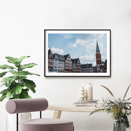 Frankfurt Poster im Querformat vom Frankfurter Römer. Bild mit weißen umlaufenden Rand, fertig gerahmt an der Wand im Wohnzimmer.