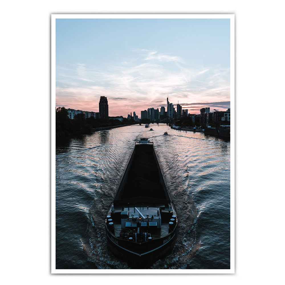 Frankfurt am Main Poster. Boot fährt über den Main, im Hintergrund die Frankfurter Skyline zum Sonnenuntergang.