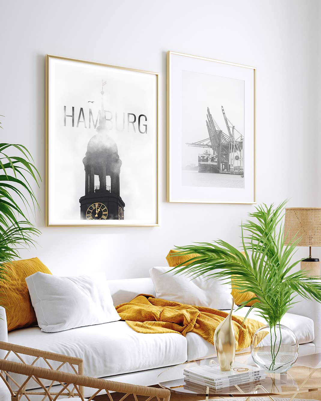 Zwei helle schwarz weiß Hamburg Poster in goldenen Rahmen über einer weißen Couch im Wohnzimmer