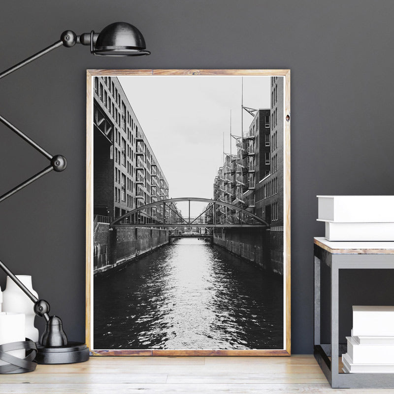 Schwarz Weiß Hamburg Poster in einem hellen Holzrahmen auf dem Boden angelehnt an eine graue Wand.
