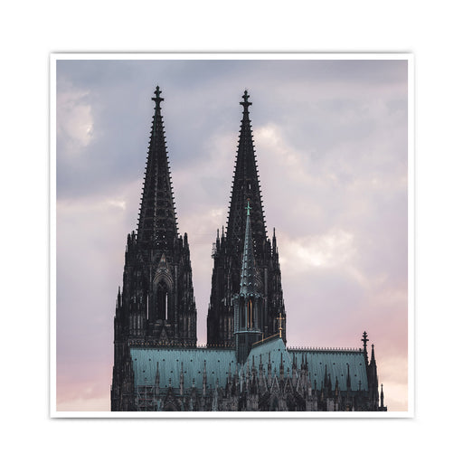 Kölner Dom Poster im Sonnenuntergang mit rötlichem Himmel. Im Vordergrund das Museum Ludwig und Bäume. Bild ist im quadratischen Format.
