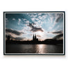 Köln Skyline Poster im Querformat. Sonnenuntergang über dem Kölner Dom bei leicht bewölkten blauen Himmel. Bild im schwarzen Bilderrahmen.