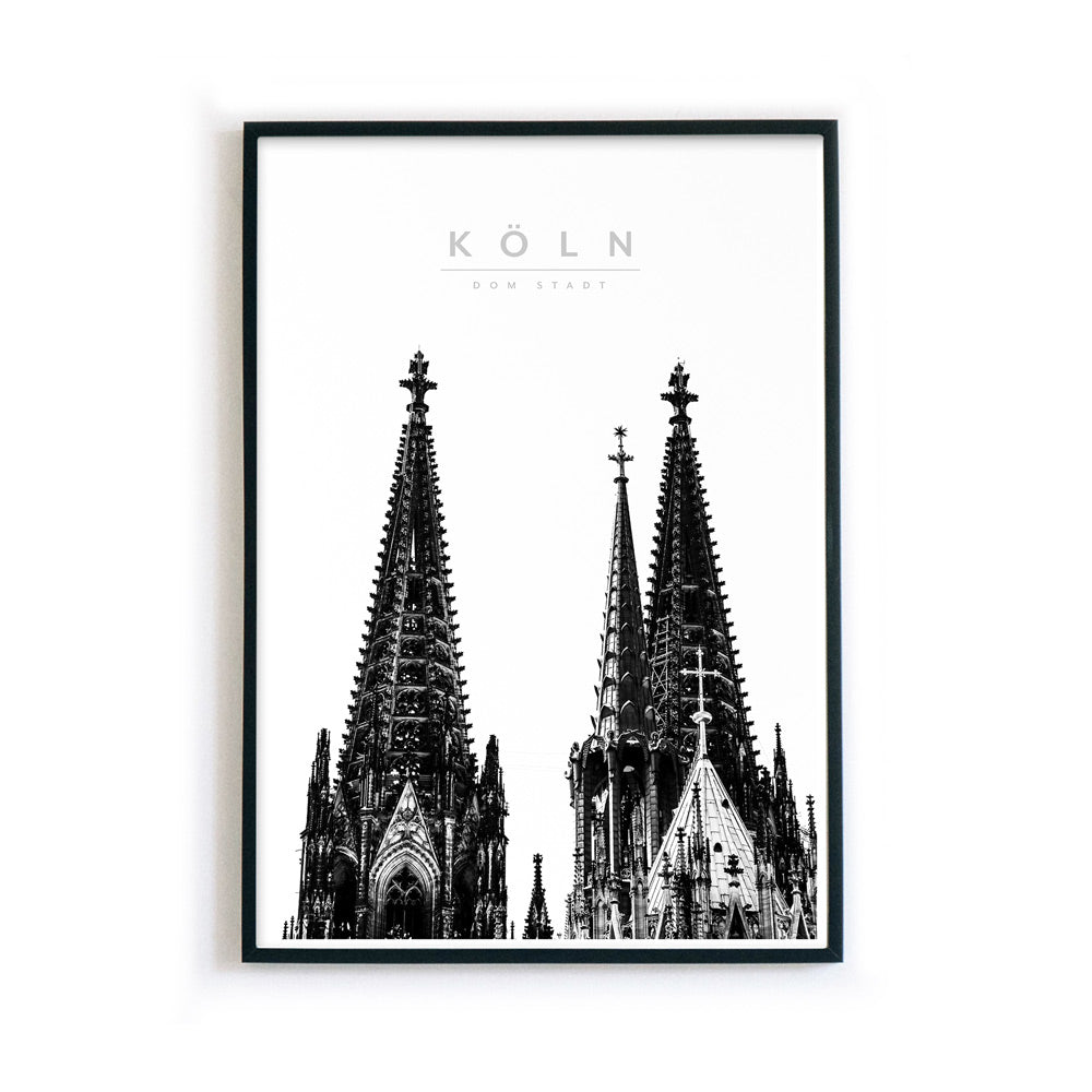 Illustriertes Kölner Dom Poster in schwarz Weiß. Die Türme vom Kölner Dom, darüber der Schriftzug - Köln Dom Stadt. Gerahmt in einem schwarzen Bilderrahmen